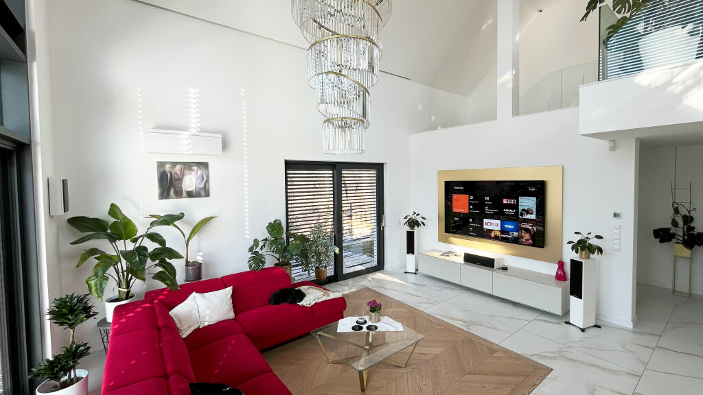 prywatne kino w pokoju dziennym. Realizacja kino w salonie Kraków - przestronne, nowoczesne wnętrze z nagłośnieniem i czerwonym narożnikiem.