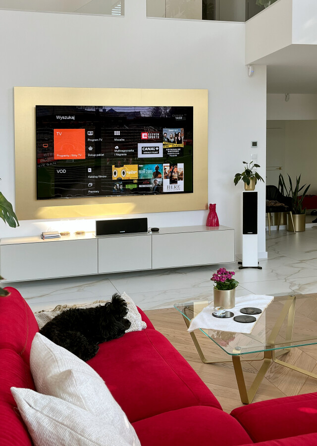 Kino domowe - Profesjonalna instalacja - kino w salonie Kraków. Telewizor w złotej ramie, zaawansowany system nagłośnienia.