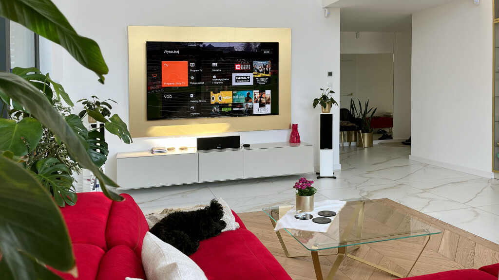 Kino domowe - Profesjonalna instalacja - kino w salonie Kraków. Telewizor w złotej ramie, zaawansowany system nagłośnienia.