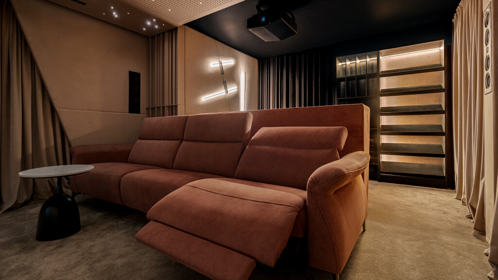 Zaawansowane kino domowe w Opolu. Instalacja z projektorem laserowym Sony XW5000 i wygodną sofą na tle paneli akustycznych.